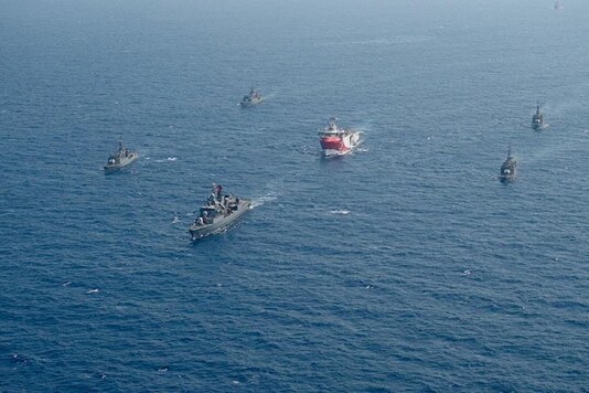FILE - In this photo taken Monday, Aug. 10, 2020, Turkey's research vessel, Oruc Reis, center, is surrounded by Turkish navy vessels as it was heading in the west of Antalya on the Mediterranean, Turkey. Greece says it will conduct a navy and air force exercise in an area of the eastern Mediterranean where Turkey is prospecting for oil and gas in an area as the neighboring countries remain locked in a dispute over offshore energy rights. (IHA via AP)