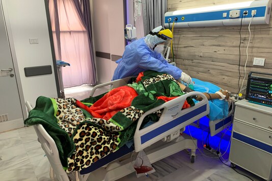 Hamza Abdulrahman Jelwal, a supervising nurse in a protective suit, cares for a patient infected with the coronavirus disease (COVID-19) at a quarantine centre, in Misrata, Libya September 7, 2020. REUTERS/Ayman Al-Sahili