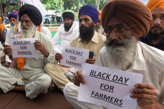 Farmers hold placards during a demonstration over farm bills in Amritsar on Friday. (AFP)