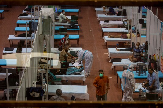 A health worker examines a patient at a makeshift Covid-19 care center set up in an indoor sports stadium, in New Delhi, on September 19, 2020. (AP Photo/Altaf Qadri)