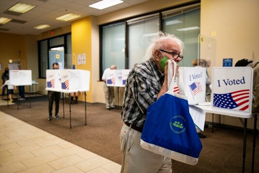 A man walks to place his ballot into a machine at an early voting site in Arlington, Virginia, U.S., September 18, 2020. REUTERS/Al Drago