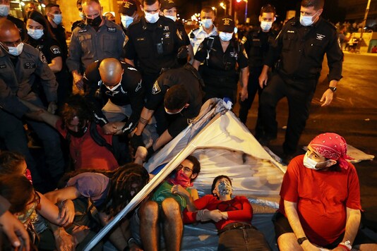 Police evacuate people during a protest against Israeli Prime Minister Benjamin Netanyahu's alleged corruption and economic hardship stemming from lockdown after Israel entered a second nationwide lockdown amid a resurgence in the new coronavirus disease (COVID-19) cases, forcing residents to stay mostly at home during the Jewish high-holiday season in Jerusalem, September 21, 2020. REUTERS/Ronen Zvulun - RC2L2J9TCDSR