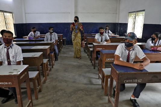 Students wearing protective masks listen to their teacher as they maintain social distancing at a Kolkata school during a demonstration on protective measures against Covid-19, on June 8, 2020. (REUTERS/Rupak De Chowdhuri)