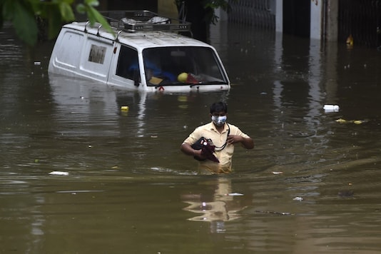A man wades through a flooded street next to a partially submerged van following heavy monsoon rains in Mumbai on September 23, 2020. (Punit PARANJPE / AFP) A man wades through a flooded street next to a partially submerged van following heavy monsoon rains in Mumbai on September 23, 2020. (Punit PARANJPE / AFP)