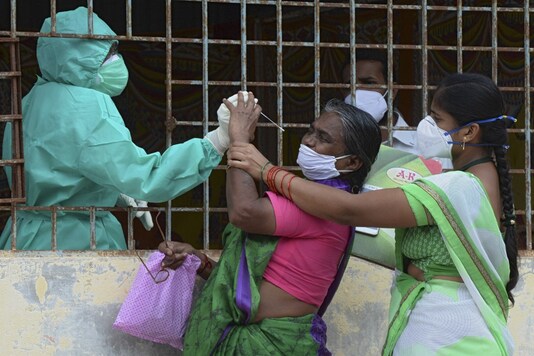 A woman reacts when a healthcare worker tries to collect her swab sample to test for Covid-19, in Hyderabad on September 23, 2020 (AFP).