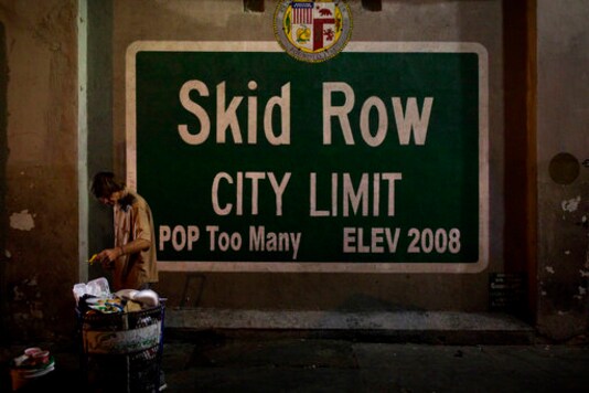 FILE - In this Oct. 28, 2017, file photo, a homeless man takes food from a trash can in Los Angeles' Skid Row area, home to the nation's largest concentration of homeless people. Starting this week, census takers are grabbing reflective vests, face masks and flashlights and heading out at night in groups of four to track down one of the hardest populations to count in the 2020 census, the homeless. (AP Photo/Jae C. Hong, File)