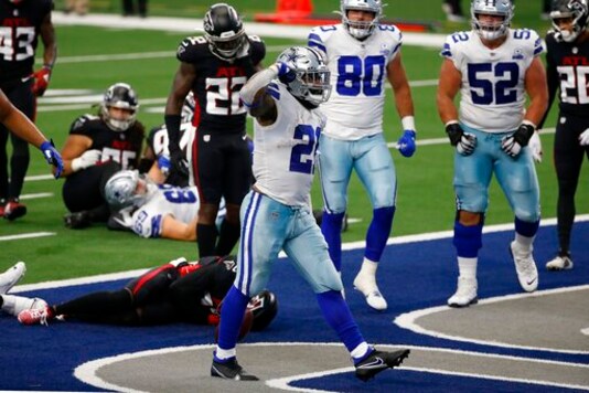 Dallas Cowboys running back Ezekiel Elliott (21) celebrates running the ball for a touchdown as Atlanta Falcons' Keanu Neal (22) checks on injured teammate Damontae Kazee, bottom, in the first half of an NFL football game in Arlington, Texas, Sunday, Sept. 20, 2020. (AP Photo/Ron Jenkins) Dallas Cowboys running back Ezekiel Elliott (21) celebrates running the ball for a touchdown as Atlanta Falcons' Keanu Neal (22) checks on injured teammate Damontae Kazee, bottom, in the first half of an NFL football game in Arlington, Texas, Sunday, Sept. 20, 2020. (AP Photo/Ron Jenkins)