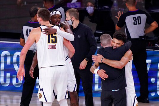 Denver Nuggets players and coaches celebrate their win over the Los Angeles Clippers in an NBA conference semifinal playoff basketball game Tuesday, Sept. 15, 2020, in Lake Buena Vista, Fla. (AP Photo/Mark J. Terrill)