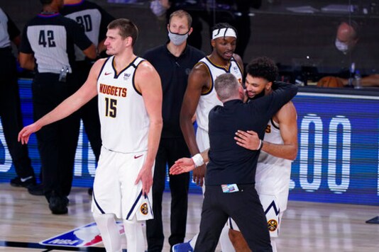 Denver Nuggets players and coaches celebrate their win over the Los Angeles Clippers in an NBA conference semifinal playoff basketball game Tuesday, Sept. 15, 2020, in Lake Buena Vista, Fla. (AP Photo/Mark J. Terrill)