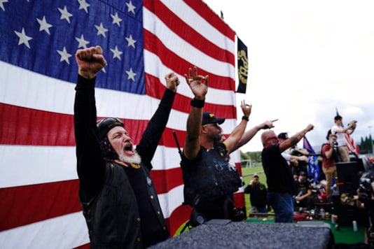 Members of the Proud Boys cheer on stage as they and other right-wing demonstrators rally, Saturday, Sept. 26, 2020, in Portland, Ore. (AP Photo/John Locher)
