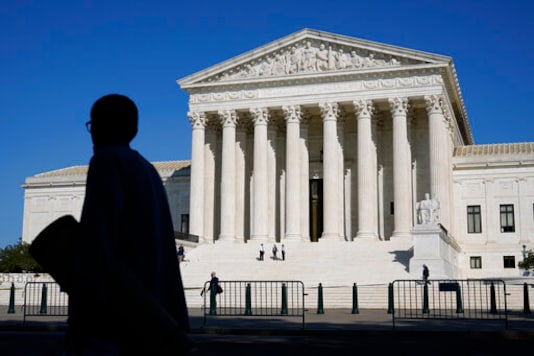 Officials stand on the Supreme Court steps on Capitol Hill in Washington, Tuesday, Sept. 22, 2020, as preparations take place for a private ceremony and public viewing in remembrance of Justice Ruth Bader Ginsburg. (AP Photo/Patrick Semansky)