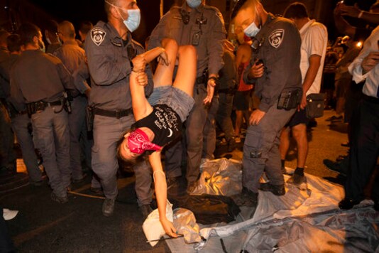 Israeli police officers detain a protester during a demonstration against Israeli Prime Minister Benjamin Netanyahu near the Prime Minister's residence in Jerusalem, Sunday, Sept. 20, 2020. (AP Photo/Sebastian Scheiner)