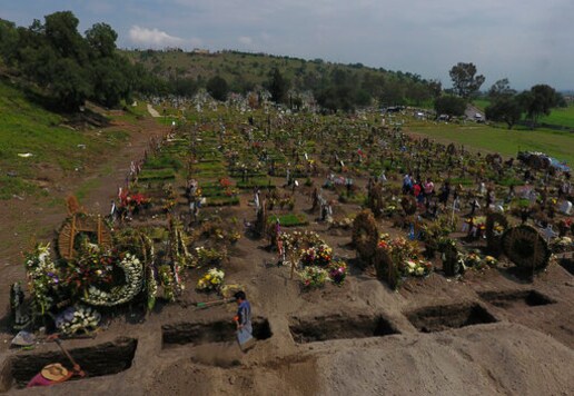 Cemetery workers dig fresh graves in a section of the Valle de Chalco Municipal Cemetery which opened early in the coronavirus pandemic to accommodate the surge in deaths, in Valle de Chalco on the outskirts of Mexico City, Thursday, Sept. 24, 2020.(AP Photo/Rebecca Blackwell)