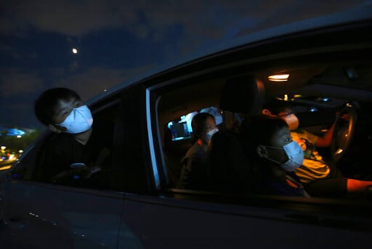 Family members in a car watch a drive-in circus from a parking lot in Seoul, South Korea, Friday, Sept. 25, 2020. The circus's aim is to provide entertainment for people during the coronavirus outbreak. (AP Photo/Ahn Young-joon)
