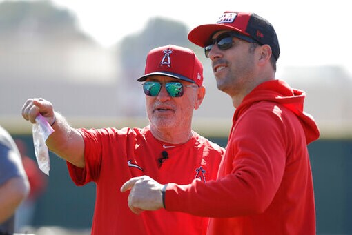 Los Angeles Angels manager Joe Maddon talks with general manager Billy Eppler during spring training baseball practice, Monday, Feb. 17, 2020, in Tempe, Ariz. (AP Photo/Darron Cummings)