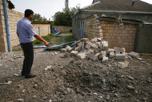 A man points to a crater that was allegedly caused by shelling during fighting over the breakaway region of Nagorno-Karabakh, in Tartar region, Azerbaijan, Wednesday, Sept. 30, 2020. Leaders of Azerbaijan and Armenia brushed off the suggestion of peace talks Tuesday, accusing each other of obstructing negotiations over the separatist territory of Nagorno-Karabakh, with dozens killed and injured in three days of heavy fighting. (AP Photo/Aziz Karimov) A man points to a crater that was allegedly caused by shelling during fighting over the breakaway region of Nagorno-Karabakh, in Tartar region, Azerbaijan, Wednesday, Sept. 30, 2020. Leaders of Azerbaijan and Armenia brushed off the suggestion of peace talks Tuesday, accusing each other of obstructing negotiations over the separatist territory of Nagorno-Karabakh, with dozens killed and injured in three days of heavy fighting. (AP Photo/Aziz Karimov)