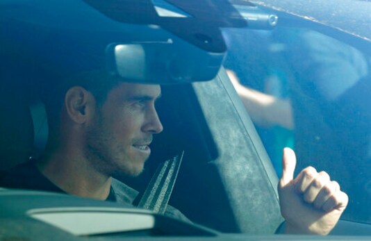 Soccer player Gareth Bale gestures to fans as he arrives at the training ground of Tottenham Hotspur in London, Friday Sept. 18, 2020. Real Madrid winger Gareth Bale is in London to complete his return to Tottenham. Bale left Tottenham for Madrid in 2013 for 100 million euros. (AP Photo/Frank Augstein)