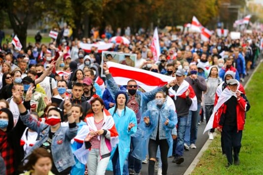 People with old Belarusian national flags march during an opposition rally to protest the official presidential election results in Minsk, Belarus, Sunday, Sept. 27, 2020.Hundreds of thousands of Belarusians have been protesting daily since the Aug. 9 presidential election. (AP Photo/TUT.by)