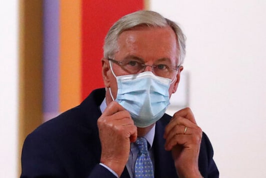 European Commission's Head of Task Force for Relations with the United Kingdom Michel Barnier puts on his protective face mask prior to meeting with European Council President Charles Michel at the EU Council building in Brussels, Friday, Sept. 18, 2020. (Yves Herman, Pool via AP)