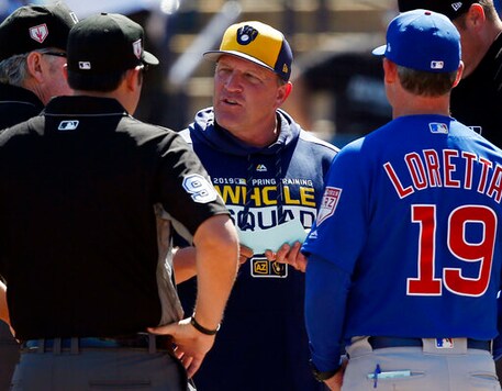 FILE - In this March 10, 2019, file photo, Milwaukee Brewers bench coach Pat Murphy, center, talks with Chicago Cubs bench coach Mark Loretta (19) and the umpires before a spring training baseball game in Phoenix. Murphy has rejoined the team six weeks after suffering a heart attack at Miller Park. Murphy said he was feeling pretty good while talking to reporters before the Brewers Friday, Sept. 18, 2020, game with the Kansas City Royals. (AP Photo/Sue Ogrocki, File)