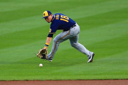 Milwaukee Brewers' Keston Hiura fields the ball and throws out Cincinnati Reds' Joey Votto at first base in the first inning during a baseball game in Cincinnati, Monday, Sept. 21, 2020. (AP Photo/Aaron Doster)