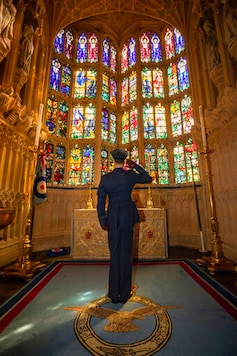 Flying Officer James Buckingham salutes The Battle of Britain memorial window inside Westminster Abbey, the stained glass window by Hugh Easton that contains the badges of the fighter squadrons that took part in the Battle, during a service to mark the 80th anniversary of the Battle of Britain at Westminster Abbey, London, Sunday, Sept. 20, 2020. (Aaron Chown/Pool Photo via AP)