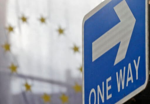 The EU flag hangs from Europa House behind a signpost in London, Tuesday, Sept. 29, 2020. Britain has entered a crucial week of post-Brexit talks with the European Union by rejectingthe EUs demand that it drop plans to breach the legally binding agreementit signed on its departure from the bloc. The EU told British Prime Minister Boris Johnson to brace for a legal fight. (AP Photo/Frank Augstein)