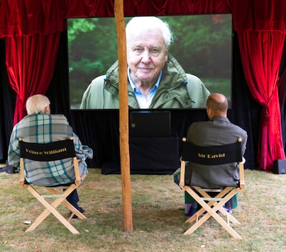 In this undated handout photo issued by WWF on Saturday, Sept. 26, 2020, British Naturalist Sir David Attenborough, sits with Prince William for a private outdoor screening of his upcoming film, David Attenborough: A Life On Our Planet, at Kensington Palace, London.(WWF via AP)