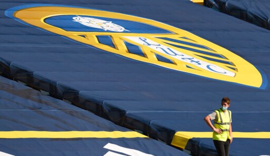 A steward wears a face mask during the English Premier League soccer match between Leeds United and Fulham at Elland Road Stadium, in Leeds, England, Saturday, Sept. 19, 2020. (Oli Scarff/Pool via AP)