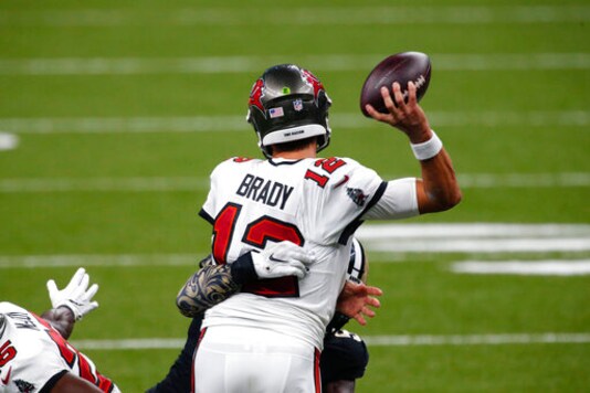 Tampa Bay Buccaneers quarterback Tom Brady (12) passes under pressure from New Orleans Saints outside linebacker Demario Davis in the second half of an NFL football game in New Orleans, Sunday, Sept. 13, 2020. (AP Photo/Butch Dill)