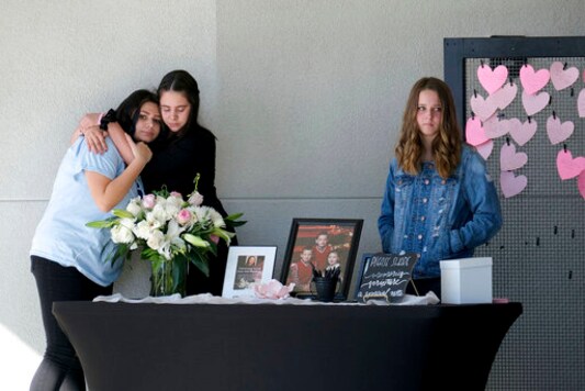 FILE - In this Nov. 23, 2019, file photo students stop at a table where mourners can write messages on pink hearts for the celebration of life for 15-year-old Gracie Anne Muehlberger, in Valencia, Calif., one of two students killed with a ghost gun in the Nov. 14, 2019, shooting at Saugus High School. California's attorney general sued the Trump administration on Tuesday, Sept. 29, 2020, in an effort to crack down on so-called 