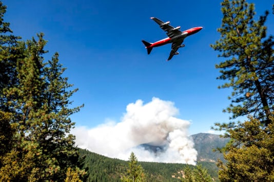 FILE - In this Sept. 17, 2020, file photo, an air tanker prepares to drop retardant while battling the August Complex Fire in the Mendocino National Forest, Calif. Rain showers fell Thursday, Sept. 24, 2020, on the northwestern edges of fire-ravaged California but forecasters warned residents to not be fooled: a new round of hot, dry and windy weather is expected by the weekend. (AP Photo/Noah Berger, File)