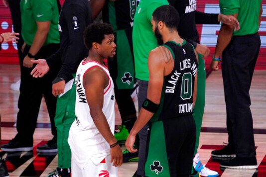 Toronto Raptors' Kyle Lowry, left, talks with Boston Celtics' Jayson Tatum after an NBA conference semifinal playoff basketball game Friday, Sept. 11, 2020, in Lake Buena Vista, Fla. The Celtics won 92-87. (AP Photo/Mark J. Terrill)