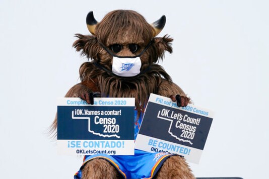 Rumble, the mascot of the Oklahoma City Thunder NBA basketball team, holds signs encouraging participation in the U.S. Census, at a drive-thru Census Mobile Questionnaire Assistance (MQA) event outside the state Capitol in Oklahoma City, Friday, Sept. 18, 2020. (AP Photo/Sue Ogrocki)