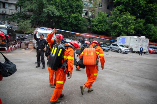 In this photo provided by China's Xinhua News Agency, rescuers arrive at a coal mine in southwest China's Chongqing Municipality, Sunday, Sept. 27, 2020. More than a dozen of people died Sunday in the coal mine in southwestern China because of excessively high levels of carbon monoxide, authorities and state media said. (Huang Wei/Xinhua via AP)