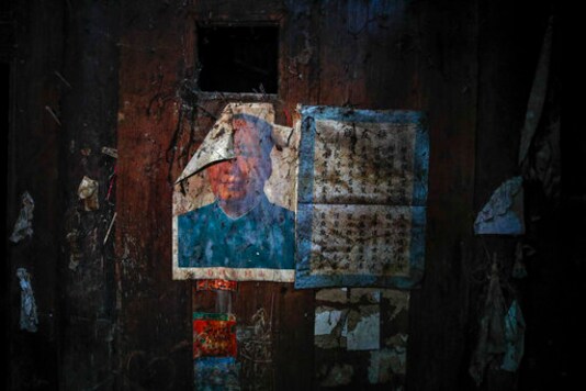 A partially damaged portrait of former leader Mao Zedong is seen inside an abandoned old house belonging to a member of Yi ethnic minority, in Qingshui village in Ganluo County, southwest China's Sichuan province, on Sept. 10, 2020. Communist Party Xi Jinpings smiling visage looks down from the walls of virtually every home inhabited by members of the Yi minority group in a remote corner of Chinas Sichuan province. Xi has replaced former leader Mao Zedong for pride of place in new brick and concrete homes built to replace crumbling traditional structures in Sichuans Liangshan Yi Autonomous Prefecture, which his home to about 2 million members of the group. (AP Photo/Andy Wong)