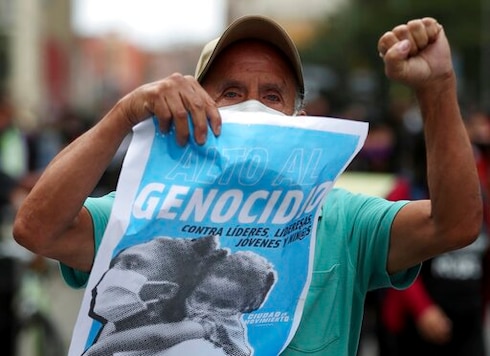 A protester holds a poster with a message that reads in Spanish: A protester holds a poster with a message that reads in Spanish: