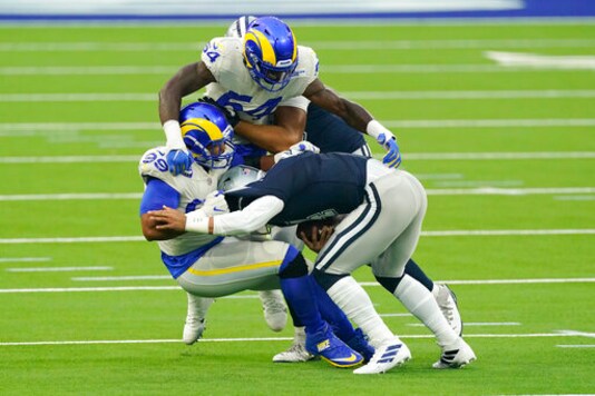 Dallas Cowboys quarterback Dak Prescott, right, is tackled by Los Angeles Rams defensive end Aaron Donald, left and outside linebacker Leonard Floyd (54) top during the first half of an NFL football game Sunday, Sept. 13, 2020, in Inglewood, Calif. (AP Photo/Ashley Landis )