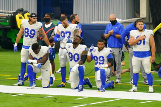 Members of the Los Angeles Rams stand and kneel during the national anthem before an NFL football game against the Dallas Cowboys Sunday, Sept. 13, 2020, in Inglewood, Calif. (AP Photo/Ashley Landis)