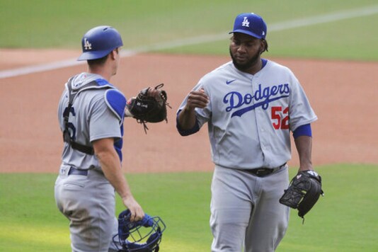 Los Angeles Dodgers relief pitcher Pedro Baez is congratulated by catcher Will Smith after the Dodgers defeated the San Diego Padres in a baseball game Wednesday, Sept. 16, 2020, in San Diego. (AP Photo/Derrick Tuskan)