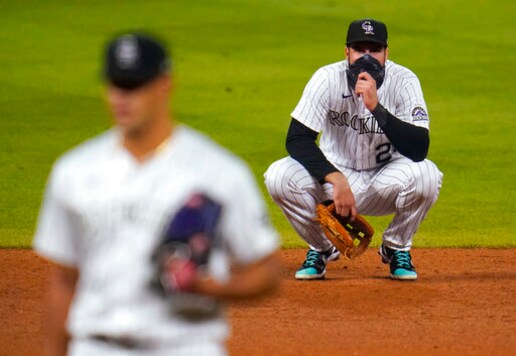 Colorado Rockies third baseman Nolan Arenado, back, waits for relief pitcher Jesus Tinoco to throw to Los Angeles Dodgers' Cody Bellinger during the ninth inning of a baseball game Thursday, Sept. 17, 2020, in Denver. The Dodgers won 9-3. (AP Photo/David Zalubowski)