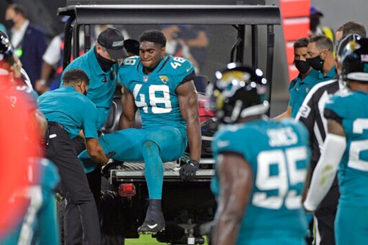 Teammates watch as Jacksonville Jaguars outside linebacker Leon Jacobs (48) is taken off the field after he was injured during the first half of an NFL football game against the Miami Dolphins, Thursday, Sept. 24, 2020, in Jacksonville, Fla. (AP Photo/Phelan M. Ebenhack)