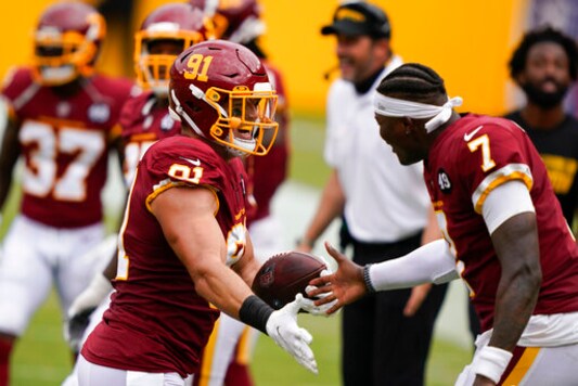 Washington Football Team defensive end Ryan Kerrigan (91) celebrates with teammate quarterback Dwayne Haskins (7) after recovering the football against Philadelphia Eagles near the end of an NFL football game, Sunday, Sept. 13, 2020, in Landover, Md. Washington won 27-17. (AP Photo/Alex Brandon)
