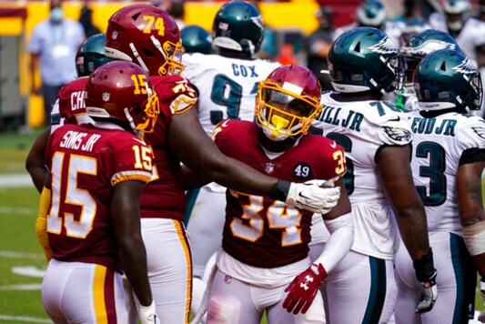 Washington Football Team running back Peyton Barber (34) celebrates his touchdown against the Philadelphia Eagles with teammates Steven Sims Jr. (15) and Geron Christian (74), during the second half of an NFL football game, Sunday, Sept. 13, 2020, in Landover, Md. (AP Photo/Alex Brandon)
