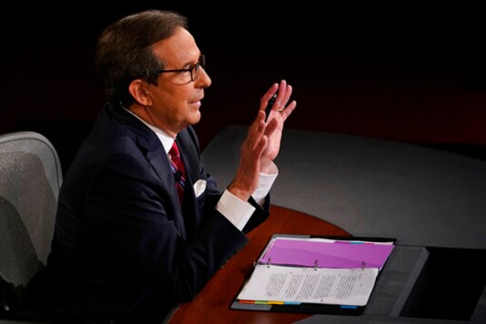 Moderator Chris Wallace of Fox News gestures toward President Donald Trump and Democratic presidential candidate former Vice President Joe Biden during the first presidential debate Tuesday, Sept. 29, 2020, at Case Western University and Cleveland Clinic, in Cleveland, Ohio. (AP Photo/Morry Gash, Pool)