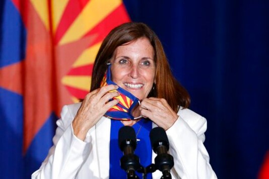 FILE - In this Tuesday, Aug. 11, 2020 file photo, Sen. Martha McSally, R-Ariz., smiles as she removes her face covering to speak prior to Vice President Mike Pence arriving to speak at the 