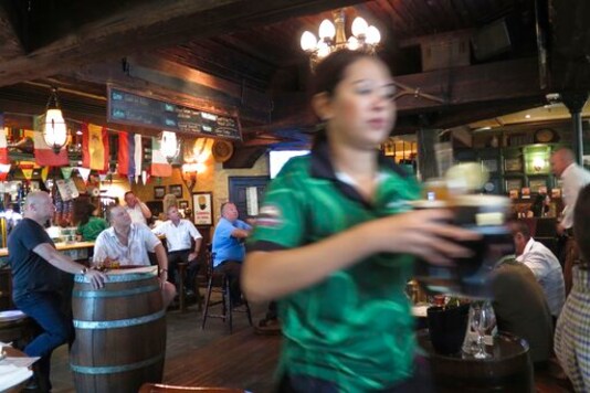 FILE - In this June 22, 2016 file photo, a waitress serves customers beer at a restaurant in Dubai, United Arab Emirates. In mid-September 2020, Abu Dhabi, the conservative capital of the United Arab Emirates, eliminated its licensing system for alcohol purchases allowing Muslims previously barred from obtaining licenses to be able to purchase from retailers. (AP Photo/Kamran Jebreili, File)