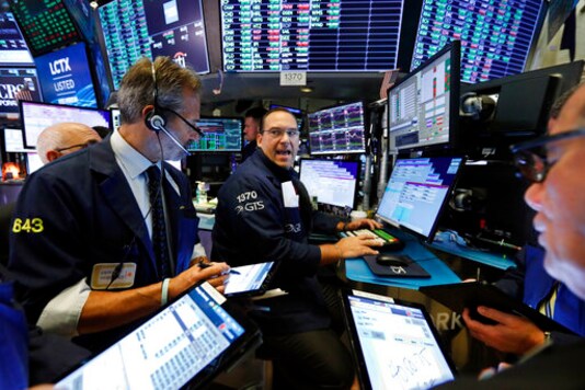 FILE - In this Aug. 21, 2019, file photo, specialist Anthony Matesic, center, works with traders at his post on the floor of the New York Stock Exchange. Stocks are opening solidly higher on Wall Street Monday, Sept. 14, 2020, following a burst of big corporate deals. (AP Photo/Richard Drew, File)