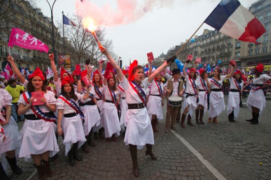 FILE - In this March 24, 2013 file photo, anti gay marriage activists dressed as Marianne, the symbol of the French Republic since the 1789 revolution, demonstrate in Paris. French women enjoy a universal reputation for their instinctive knack for spot-on chic attire. Ministers, already working overtime to tamp down the coronavirus spread and ramp up the economy, have gotten side-tracked in a debate about whether crop tops or other skimpy clothing on girls in classrooms is acceptable or a grave affront to the French Republic. (AP Photo/Michel Euler; File)