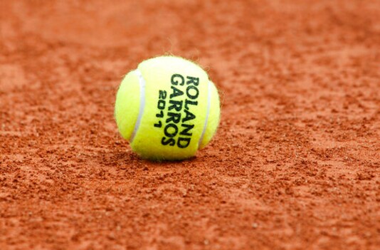 FILE - In this May 20, 2011, file photo, a tennis ball is seen on the clay at the Roland Garros stadium in Paris. The French Open begins Sunday, Sept. 27, 2020. (AP Photo/Christophe Ena, File)